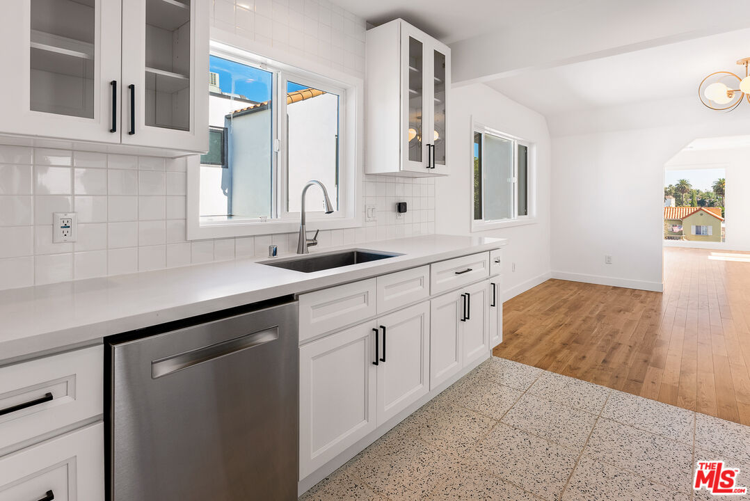 1253 South Rimpau Boulevard Los Angeles, CA 90019 - Photo 15 of 71 a kitchen with white cabinets and sink