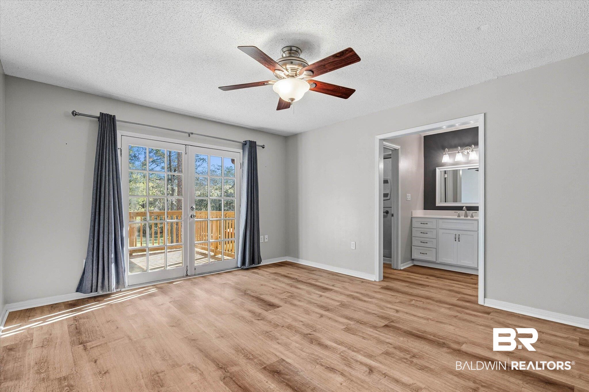 8030 Country Drive Mobile, AL 36619 - Photo 10 of 22 Unfurnished bedroom featuring access to exterior, light wood finished floors, a textured ceiling, ensuite bath, and a ceiling fan