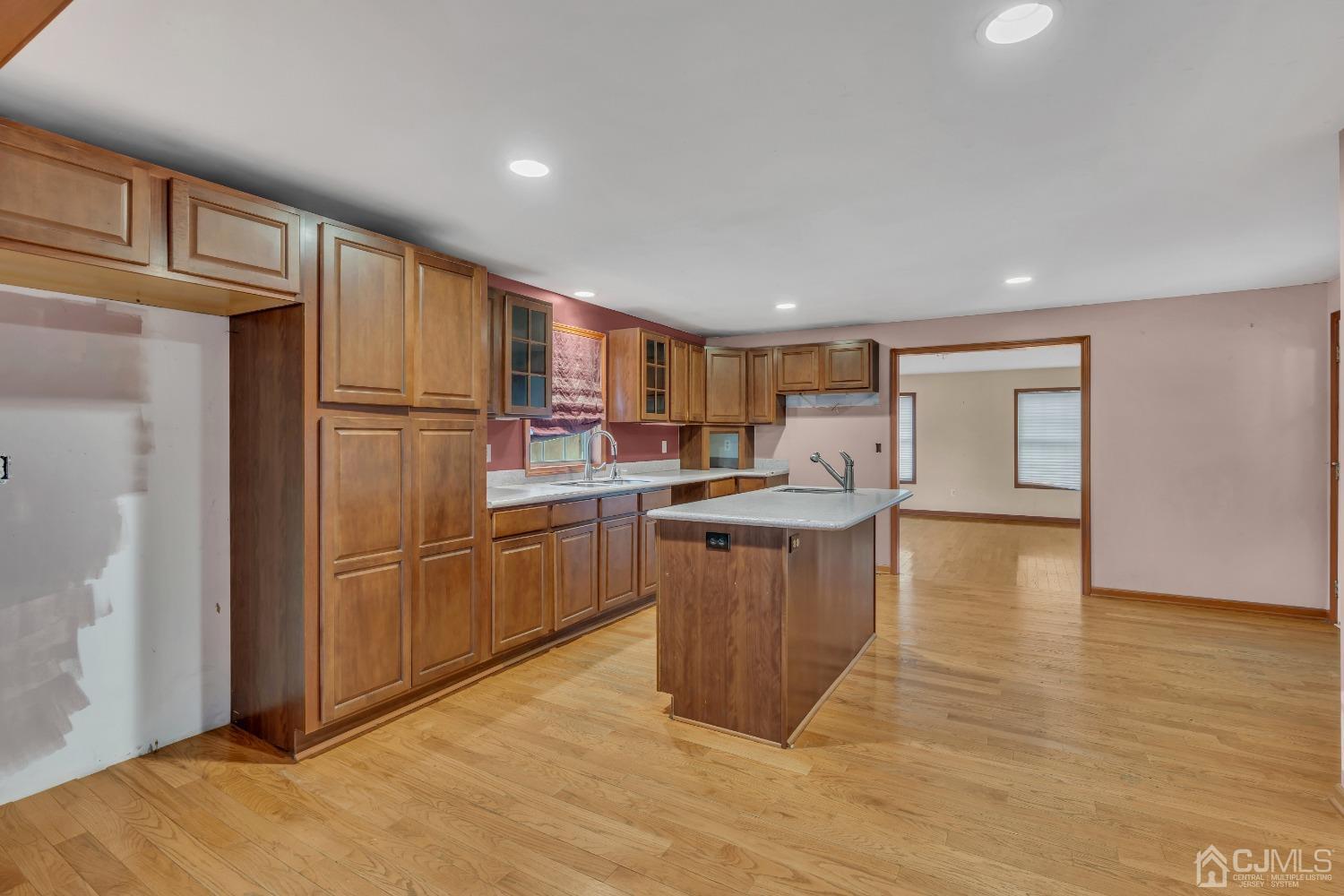 231 Station Road Monroe Township, NJ 08831 - Photo 7 of 36 a kitchen with refrigerator cabinets and wooden floor