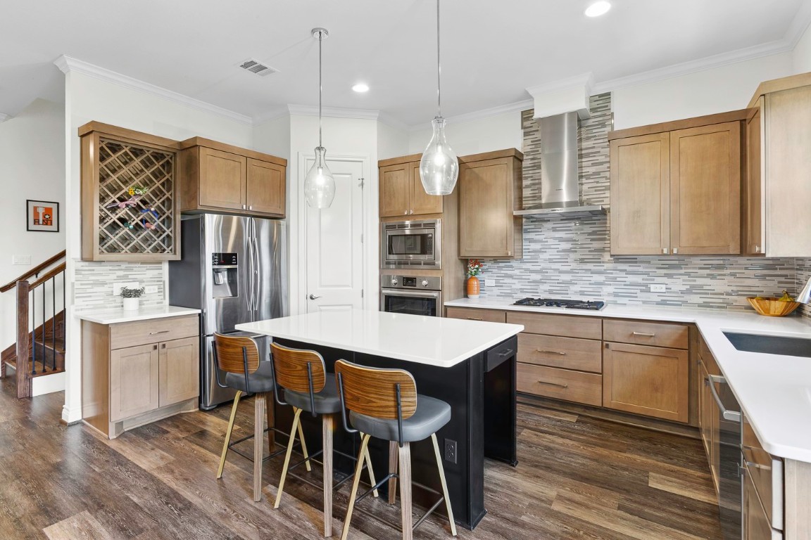 a kitchen with stainless steel appliances granite countertop a dining table chairs sink refrigerator and microwave