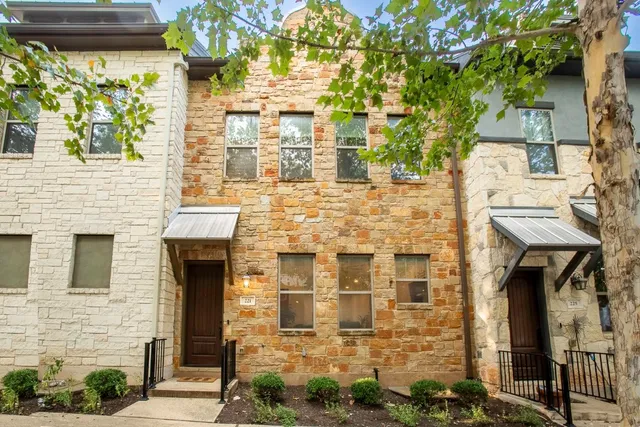 a front view of a building with a tree