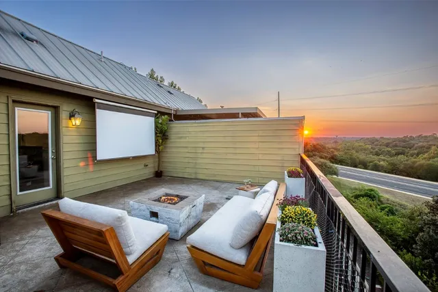 a roof deck with couches and potted plants