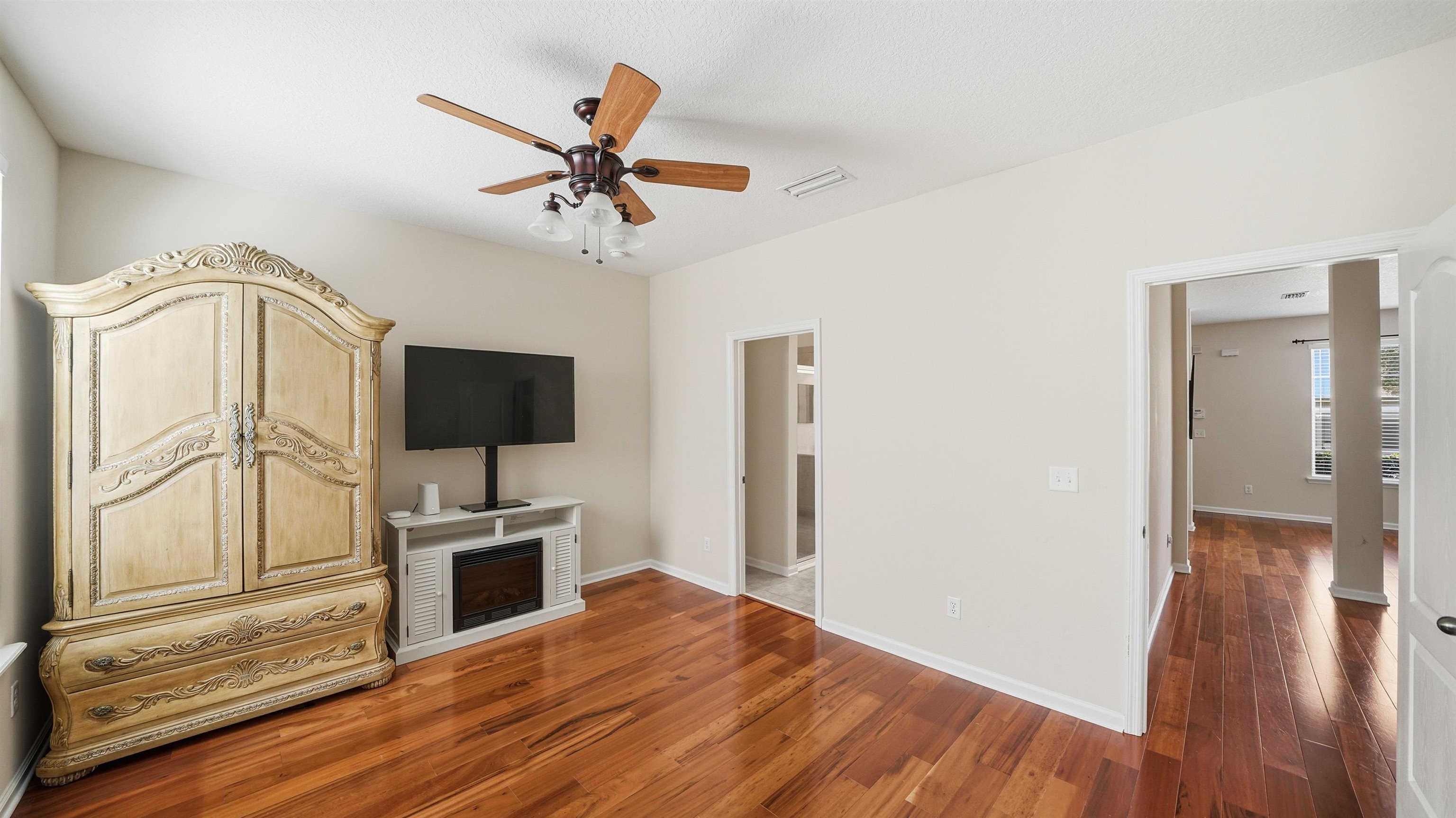 1121 Overdale Road St. Augustine, FL 32080 - Photo 15 of 65 a view of a livingroom with a flat screen tv wooden floor and a ceiling fan