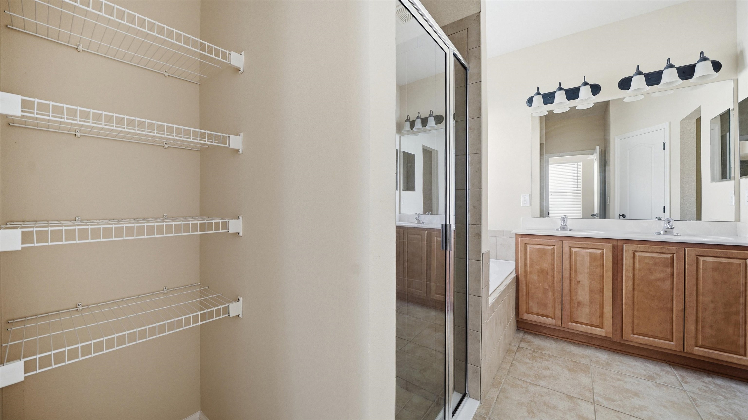 1121 Overdale Road St. Augustine, FL 32080 - Photo 16 of 65 Full bathroom with double vanity, light tile patterned floors, and tiled bath