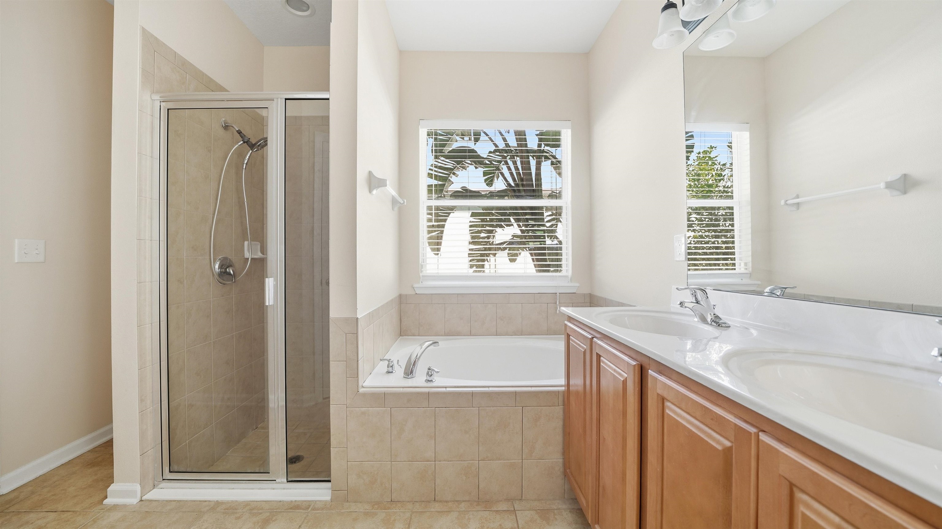 1121 Overdale Road St. Augustine, FL 32080 - Photo 20 of 65 a bathroom with a granite countertop sink a mirror a bathtub and next to a window