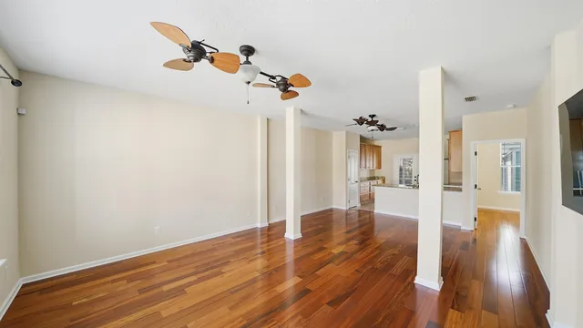 a view of a livingroom with wooden floor and a ceiling fan