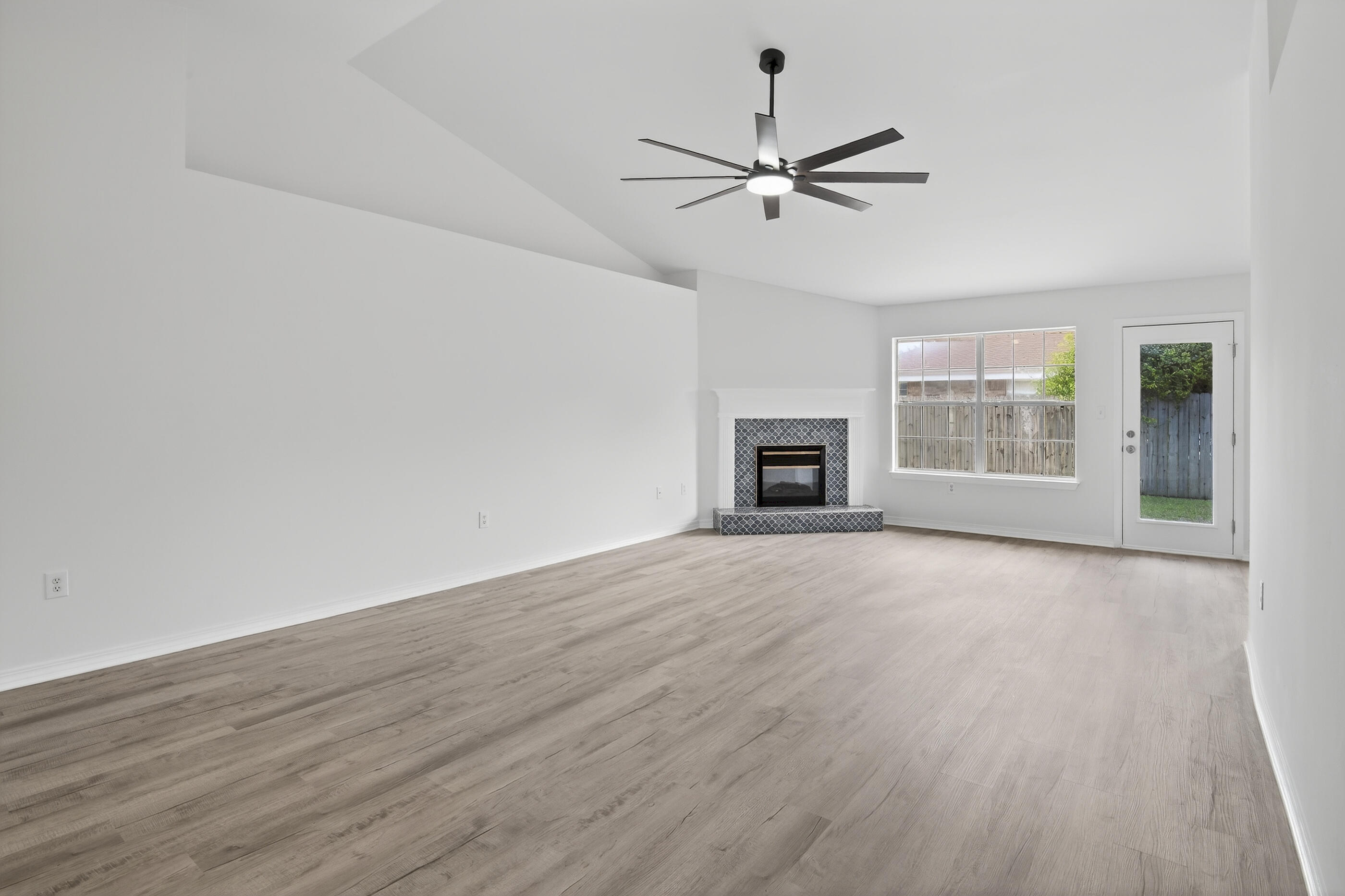 151 Beacon Way Miramar Beach, FL 32550 - Photo 21 of 42 an empty room with wooden floor ceiling fan and windows