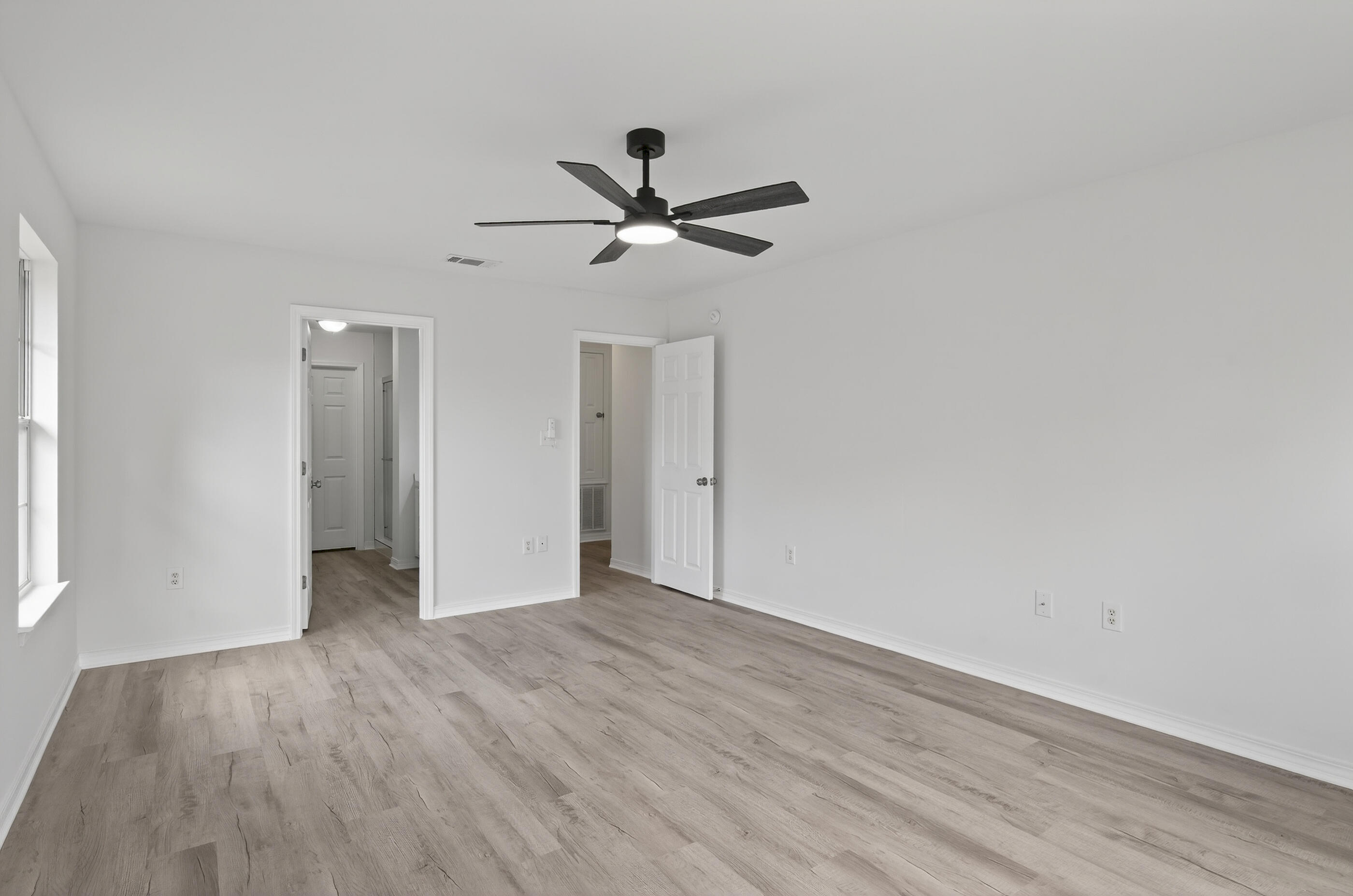 151 Beacon Way Miramar Beach, FL 32550 - Photo 28 of 42 an empty room with wooden floor ceiling fan and window
