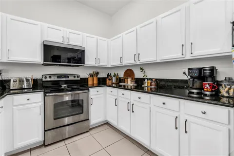 a kitchen with white cabinets and white appliances