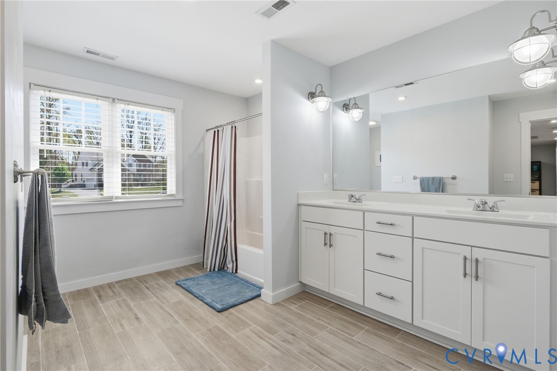 605 Carldan Road Richmond, VA 23227 - Photo 28 of 38 a bathroom with a sink double vanity and a mirror