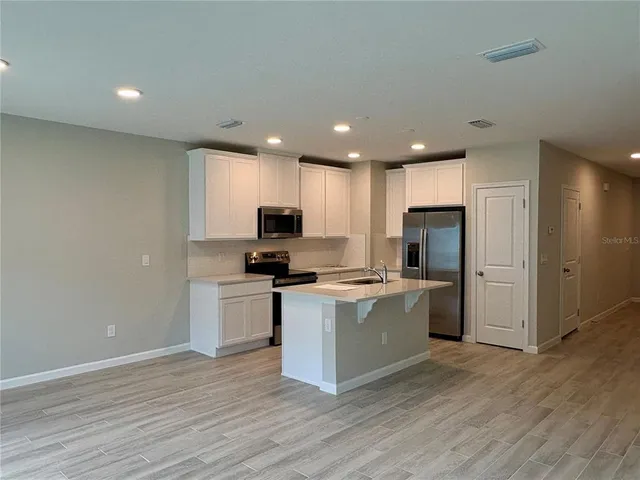 a kitchen with stainless steel appliances a refrigerator stove a sink and a microwave