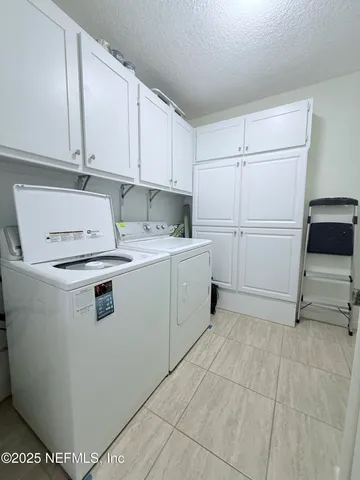 a utility room with cabinets washer and dryer