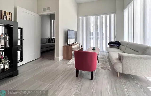 a living room with furniture and large windows