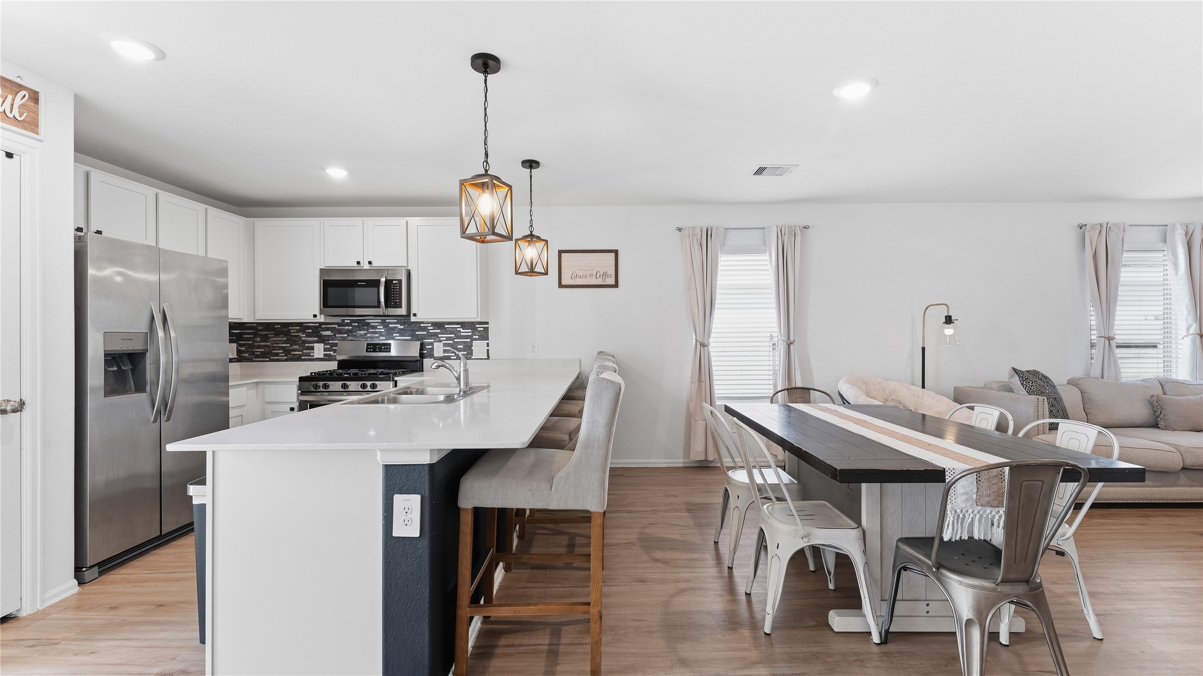 126 Spring Rose Drive Magnolia, TX 77354 - Photo 21 of 48 a kitchen with a dining table chairs refrigerator and microwave