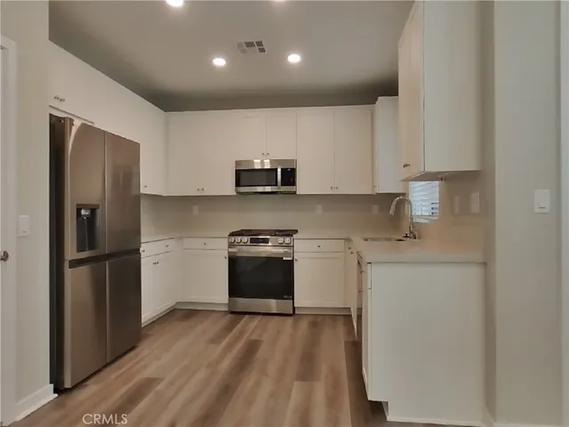 a kitchen with stainless steel appliances a refrigerator stove microwave and sink