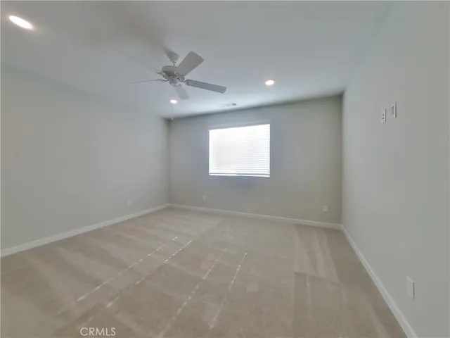 an empty room with a window and ceiling fan