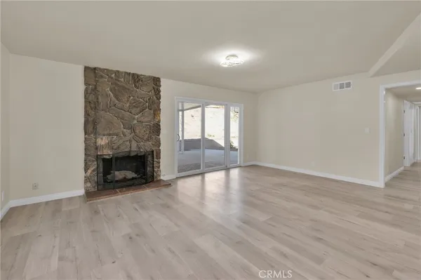 wooden floor in an empty room with a fireplace