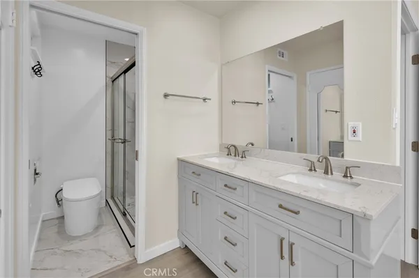 a bathroom with a granite countertop sink toilet and shower