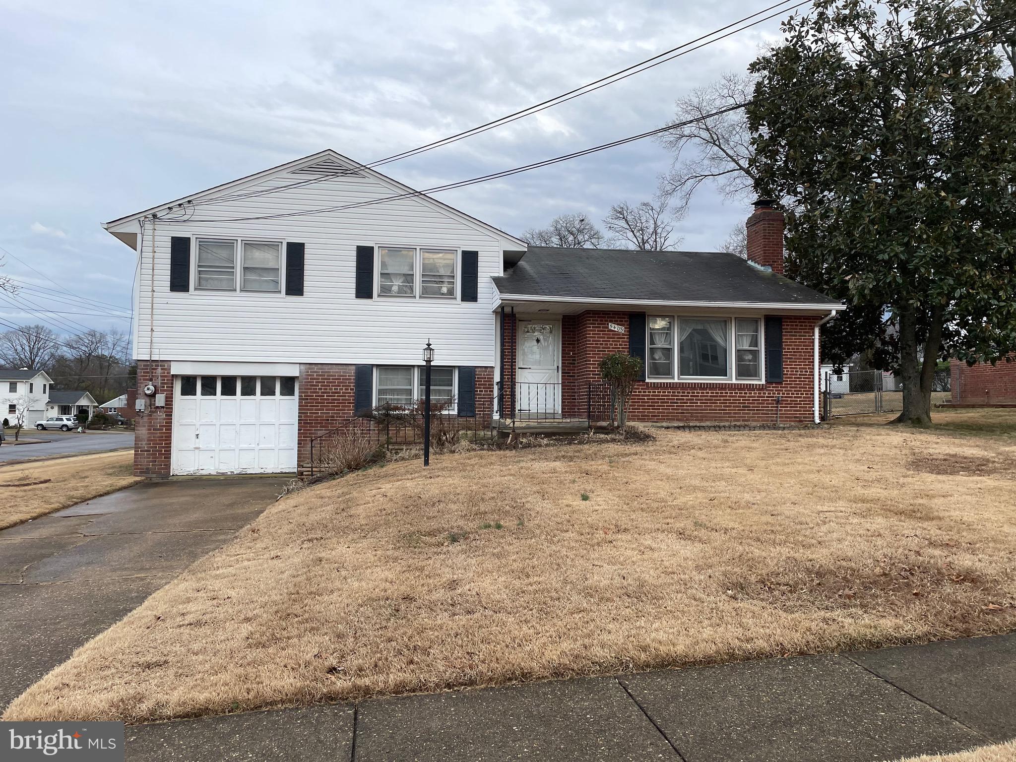 5409 Montgomery Street Springfield, VA 22151 - Photo 2 of 8 a front view of a house with a yard and garage