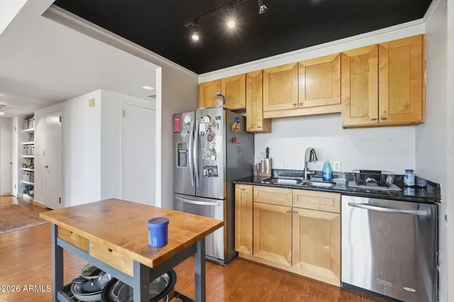 a kitchen with stainless steel appliances granite countertop a refrigerator and a stove top oven