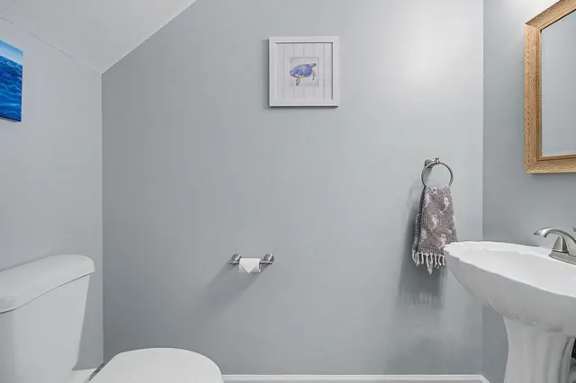 a bathroom with a sink mirror and toilet