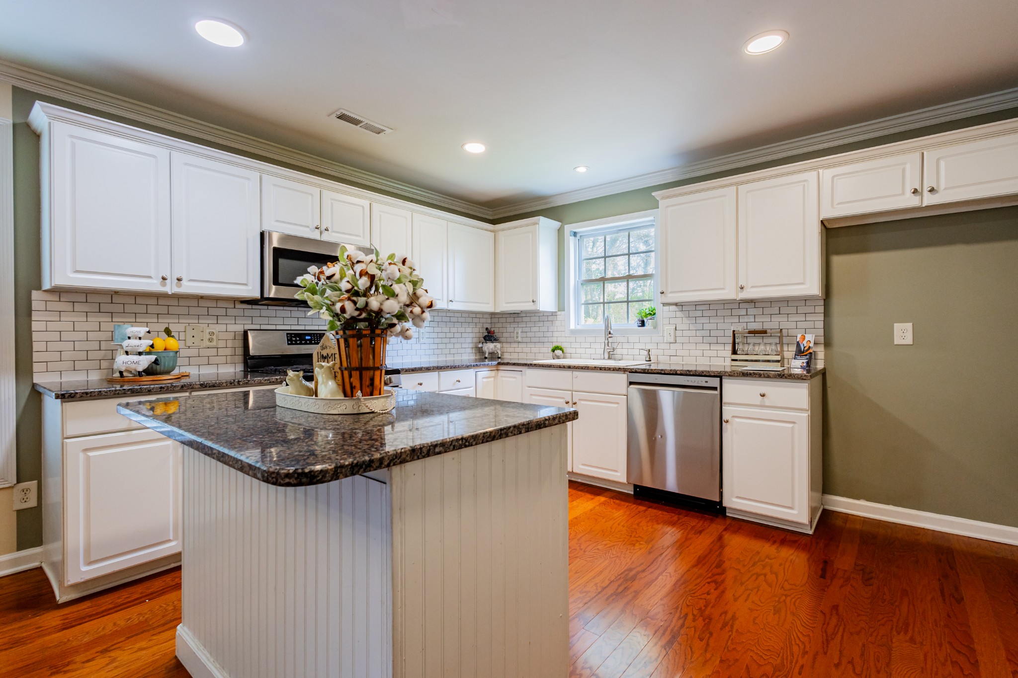 2236 Hayward Lane Spring Hill, TN 37174 - Photo 9 of 59 a kitchen with kitchen island granite countertop a sink cabinets and wooden floor