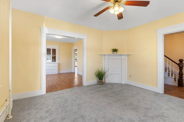 a view of a livingroom with a chandelier fan and wooden floor