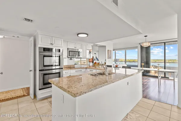 a large kitchen with granite countertop a large counter top stainless steel appliances and cabinets