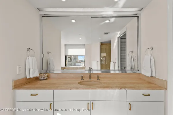 a bedroom with a white bed and dresser