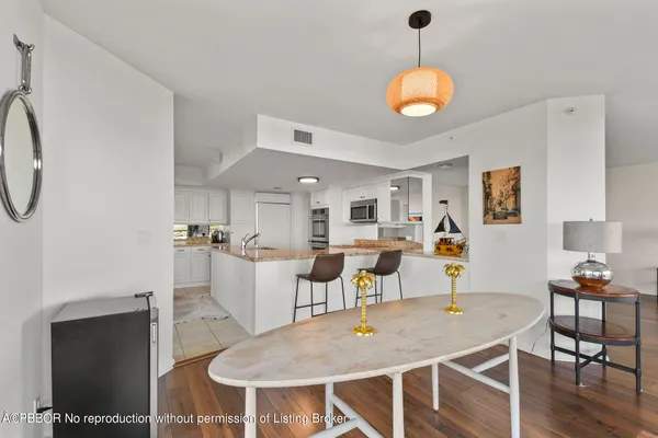 a dining room with wooden floor a chandelier a wooden table and chairs