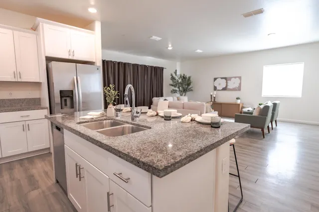 a kitchen with granite countertop a sink and a refrigerator