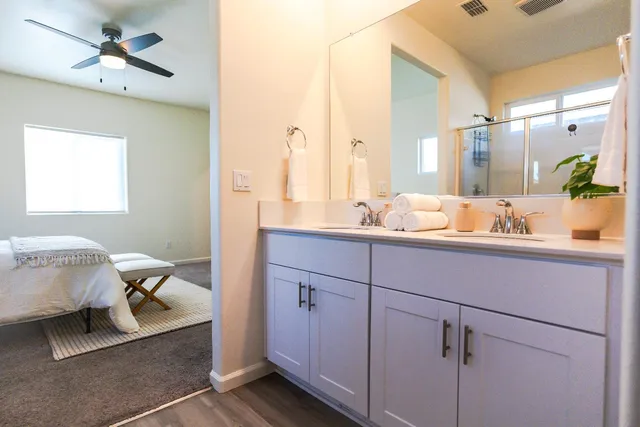 a en suite bathroom with a double vanity sink and a mirror
