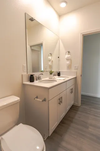 a bathroom with a double vanity sink and a toilet