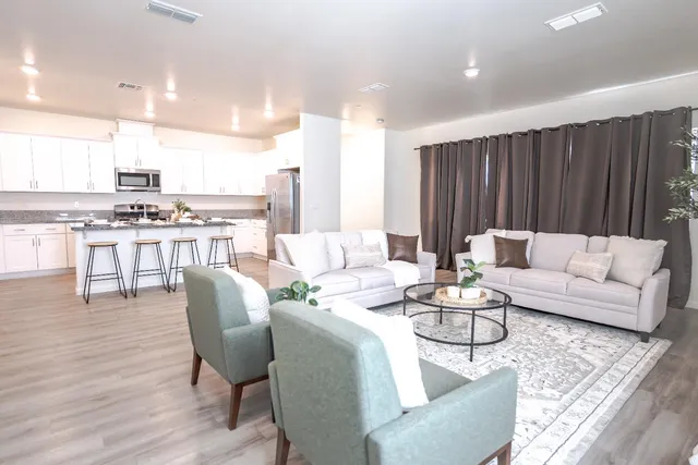a living room with furniture kitchen and a table