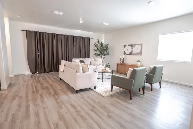 a living room with furniture and a wooden floor