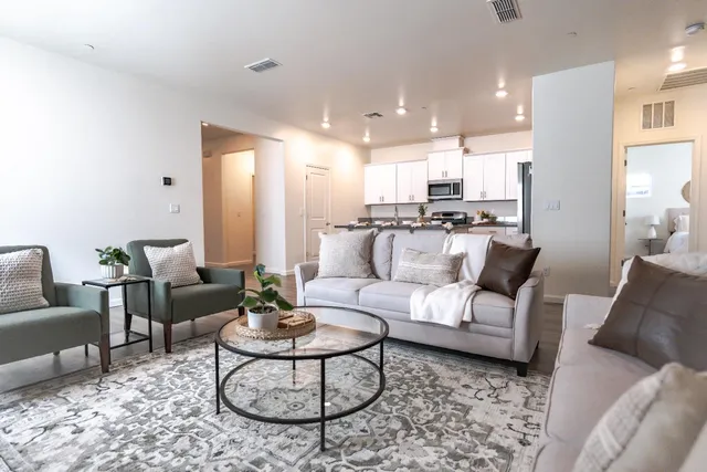 a living room with furniture kitchen and a table