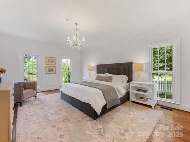 a bedroom with a large bed and a chandelier