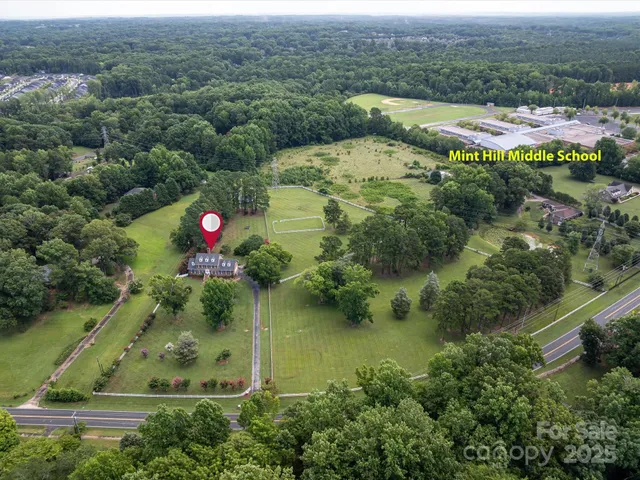 an aerial view of residential houses with outdoor space and pool