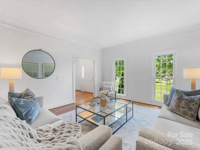a living room with furniture a lamp and a large window