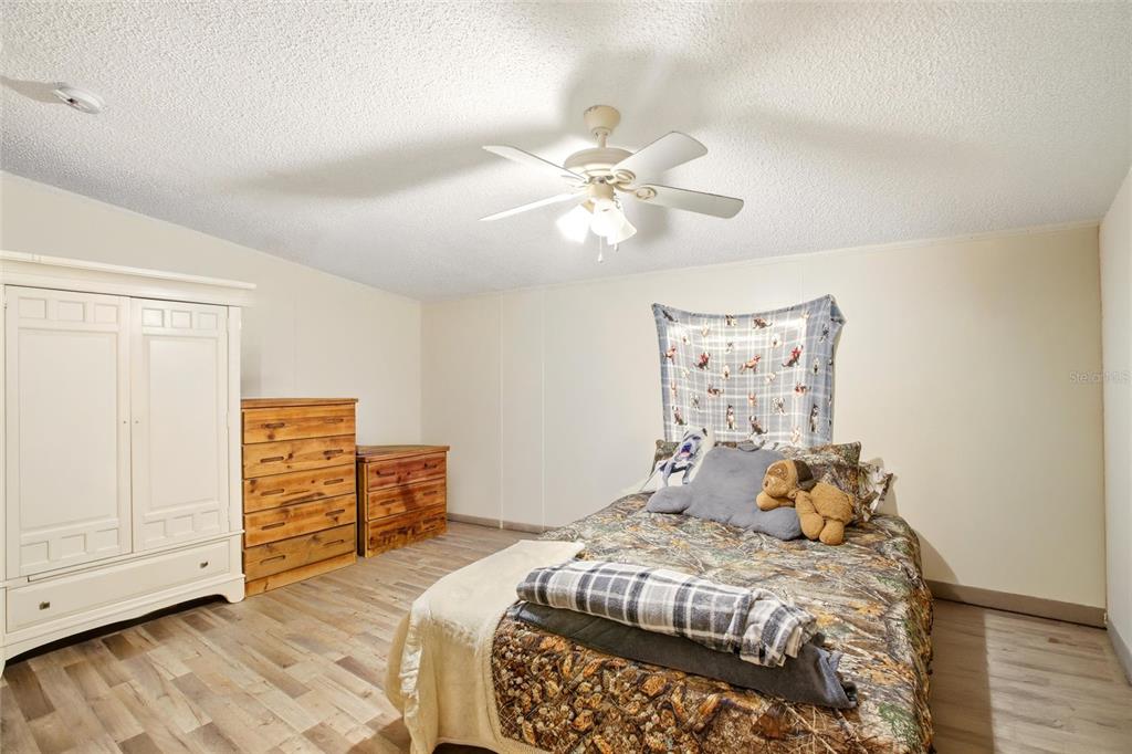 12368 Lexington Place Arcadia, FL 34269 - Photo 17 of 31 a bedroom with a bed and a chandelier