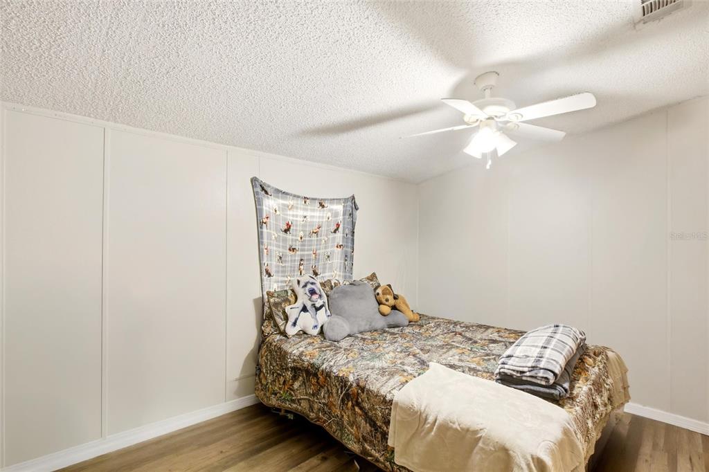 12368 Lexington Place Arcadia, FL 34269 - Photo 18 of 31 a bedroom with a bed and a chandelier