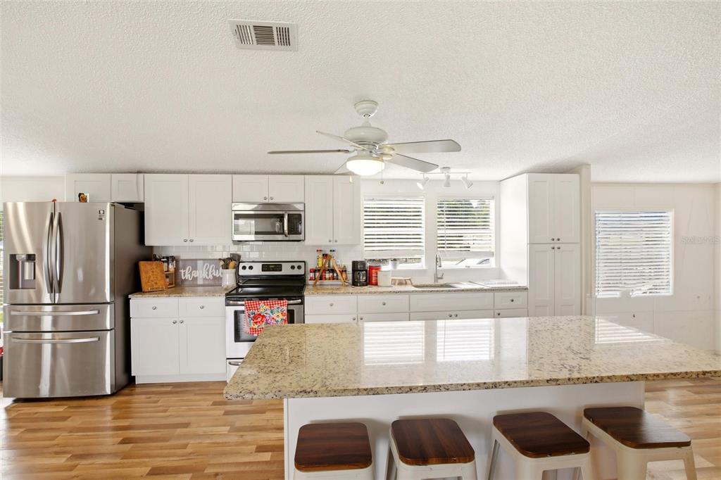 12368 Lexington Place Arcadia, FL 34269 - Photo 8 of 31 a kitchen with granite countertop a refrigerator and a stove top oven