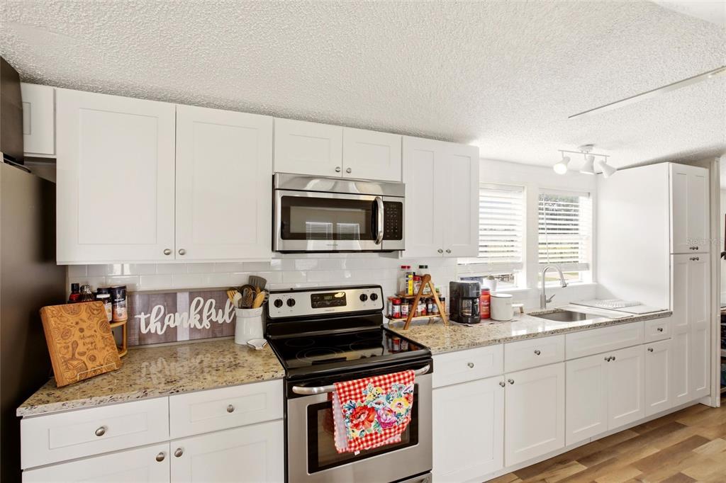 12368 Lexington Place Arcadia, FL 34269 - Photo 9 of 31 a kitchen with stainless steel appliances granite countertop a stove a sink and a microwave