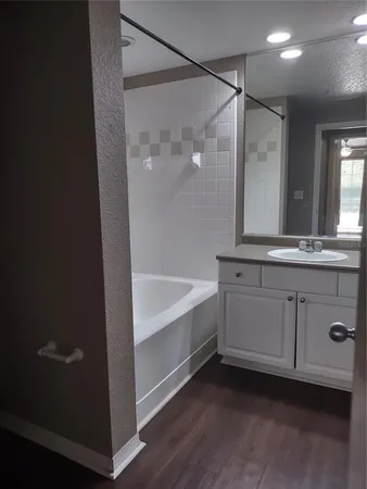 a bathroom with a bathtub and a double vanity sink