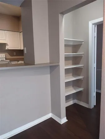 a view of a kitchen with wooden floor and cabinets