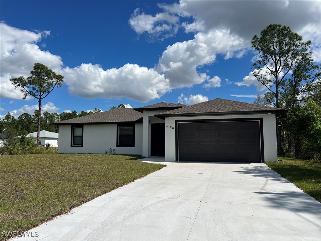 2102 Robert Avenue Alva, FL 33920 - Photo 2 of 24 a front view of a house with a yard and garage