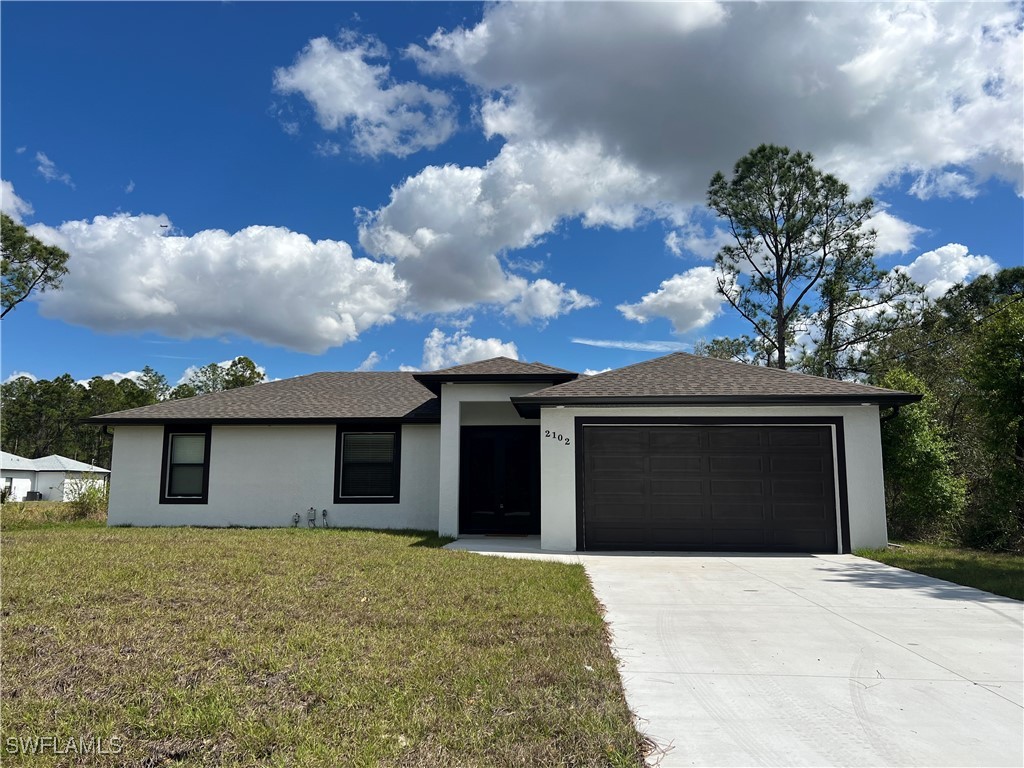 2102 Robert Avenue Alva, FL 33920 - Photo 4 of 24 a front view of a house with a yard and garage