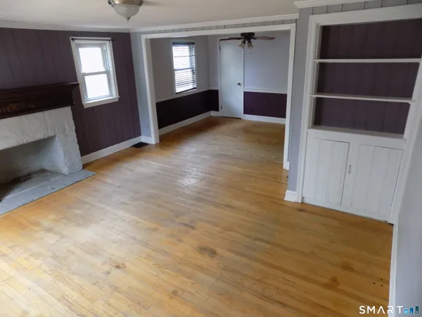 a view of empty room with wooden floor and fireplace