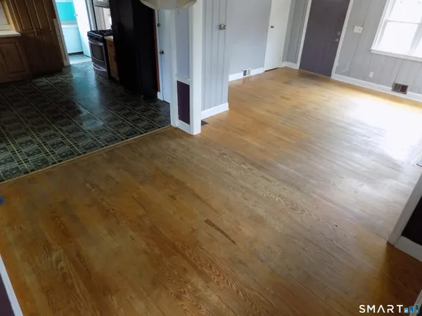 a view of empty room with wooden floor