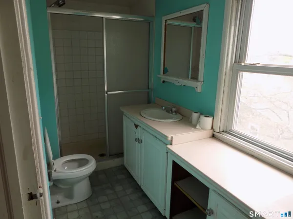 a bathroom with a sink a toilet and a window